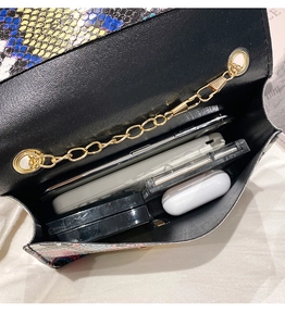 Internal capacity of snakeskin crossbody bag showing phone and daily essentials