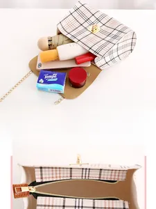 Close-up of beige plaid tote bag showing spacious interior with zipper pocket and metal chain
