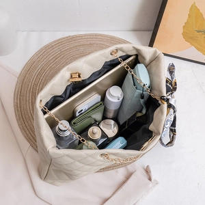 Quilted cream tote bag with gold chain and silk scarf showing large capacity for essentials