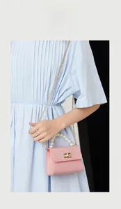 Close-up of pink mini faux-croc jelly bag with pearl handle and golden chain strap