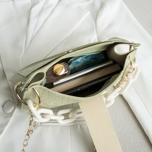Light green hobo bag with crocodile pattern and interior storage for essentials