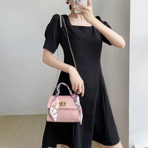 Pink leather handbag with a scarf-wrapped handle and golden chain strap for women