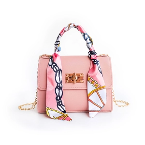 Pink crossbody bag with silk scarf handle, gold chain strap, and turn-lock closure