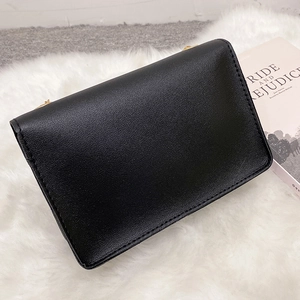 Minimalist black faux leather crossbody bag with chain strap and gold hardware accents