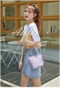 Detail of purple daisy bucket bag with white leather handles and aesthetic floral print