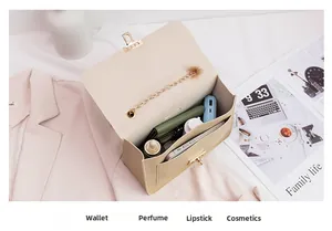 Detail view of large storage capacity for chain shoulder bag showing makeup and phone