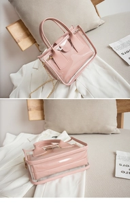 Close-up of pink transparent PVC jelly bag with inner pouch and gold chain strap details