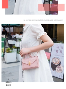 Light pink crocodile pattern mini bag worn by model with white dress on street