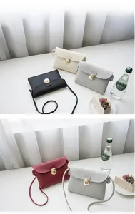 Detail of four colorful PU leather crossbody bags with golden circular metal buckles