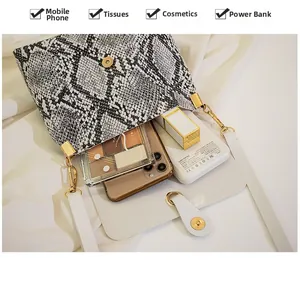 Interior view showing the capacity of snake pattern crossbody bag with golden hardware