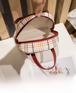 Detailansicht des geräumigen Innenraums und Reißverschlusses des Mini-Rucksacks mit Karomuster