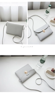Detail view of a light gray leather crossbody bag featuring a golden clasp and slim strap