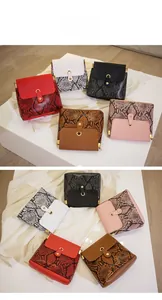 Close-up of snake skin pattern textures and gold ring hardware on stylish crossbody bags