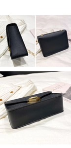 Detail view of the black PU leather crossbody mini bag with gold chain and twist lock
