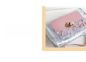 Detail of laser holographic clear bag with precise stitching and gold rotating lock
