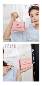 Close-up of pink mini crocodile pattern bag with pearl handle and golden chain