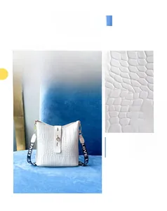 Detail of white crocodile pattern bucket bag with gold clasp and LOVE letter strap