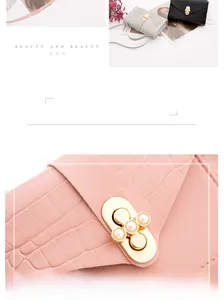 Macro view of crocodile embossed leather texture and pearl buckle detail on mini bag