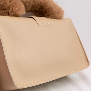 Beige faux leather handbag with brown plush fur handle and visible white stitching details