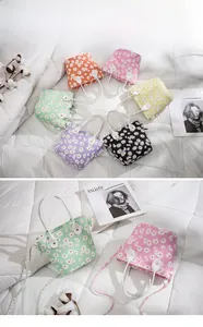Daisy print canvas bucket bags shown in six colors with leather handles and straps