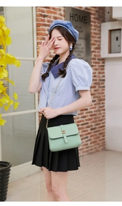 Mint green crossbody chain bag shown on model featuring a minimalist flap and metal snap