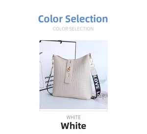 Detail of white crocodile pattern bucket bag with gold hardware and LOVE strap