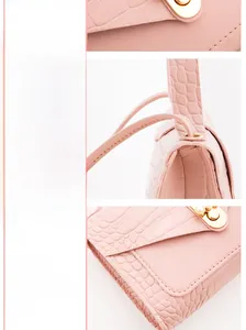 Detail of pink crocodile embossed leather bag with pearl gold buckle and fine stitching