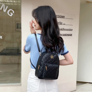 Chic black quilted mini backpack with gold zippers for women, stylish outdoor street look