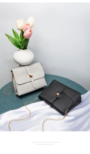 Detail of elegant chain crossbody bags in beige and black with gold metal hardware buckle