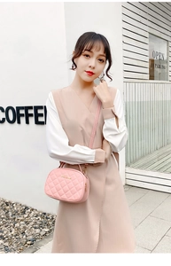 Détails du sac caméra matelassé rose avec logo doré porté par un mannequin femme