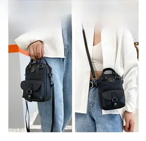 Detail of black mini multifunctional bag with TB logo showing crossbody and handbag styles