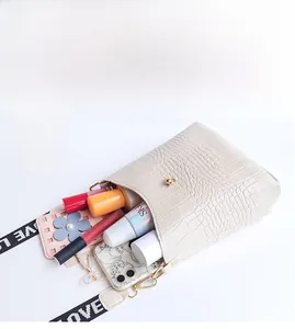 Capacity view of crocodile pattern bucket bag showing storage for phone and cosmetics