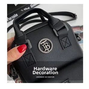 Close-up of pebble leather crossbody bag with silver TB metal hardware and fine stitching