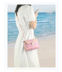 Detail view of pink crossbody bag with laser geometric pattern and metal snap button