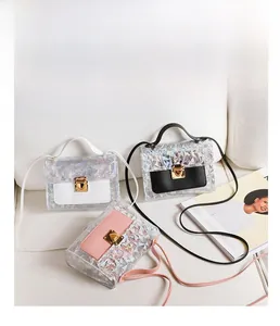 Detailed view of three holographic sequined square crossbody bags in black, white, and pink