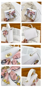 Detail view of white crocodile pattern bag with pink silk scarf and golden buckle