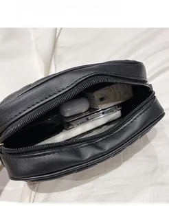 Top view of open quilted crossbody camera bag showing interior capacity with daily essentials