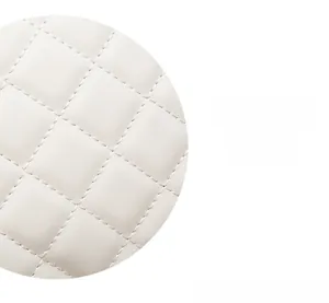 Gros plan d'un sac à main en cuir blanc avec un motif matelassé en losanges et coutures fines