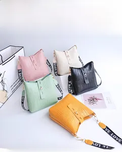 Detailed overhead view of various crocodile pattern bucket bags with wide LOVE straps