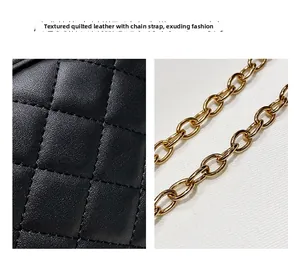 Detailed view of black quilted leather texture and golden metal chain link strap