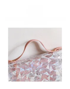 Detail of pink wide handle on transparent PVC sequin crossbody bag with triangle pattern