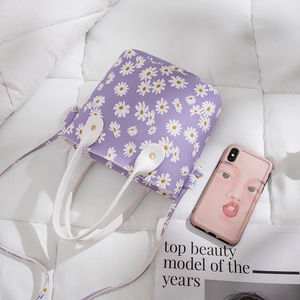 Purple bucket bag with white daisy print and white handles for summer styling