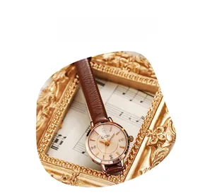 Close-up of GEDI ladies quartz watch with rhinestone markers on vintage music sheet