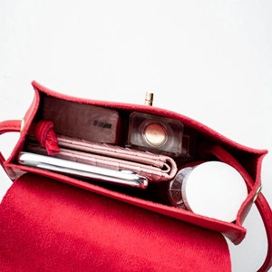 Red leather crossbody bag showing inner space with phone, wallet and cosmetics