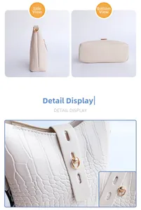 Detail view of white crocodile pattern bucket bag with gold hardware and woven strap