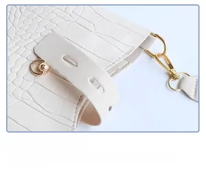 Close-up of white crocodile pattern leather texture with premium gold metal hardware