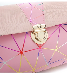 Close-up of pink geometric crossbody bag with lizard pattern texture and gold buckle