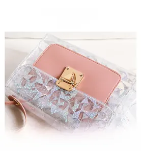 Detail of sequined geometric texture and gold twist lock on a transparent handbag
