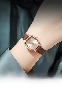 Close-up of minimalist GEDI square quartz watch with brown leather strap on wrist