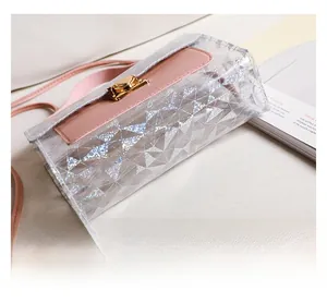 Detail of holographic geometric sequins on transparent PVC crossbody bag with pink leather strap
